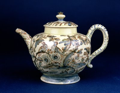 Tetera de loza de Staffordshire conocida como La Tetera de Tunstall decorada con tres pájaros en follaje oriental, pintada en manganeso marrón con el contorno resaltado en azul y verde bajo vidriado por F. Morg de English School